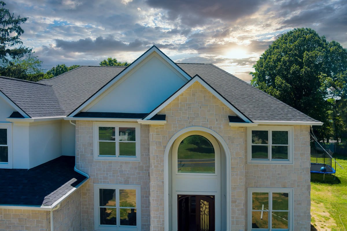 Asphalt-shingle roof on a modern stone-and-siding home