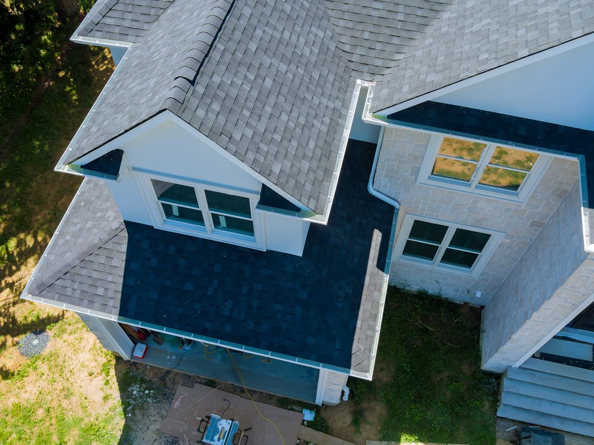 Aerial view of asphalt shingles on a modern stone-and-siding home